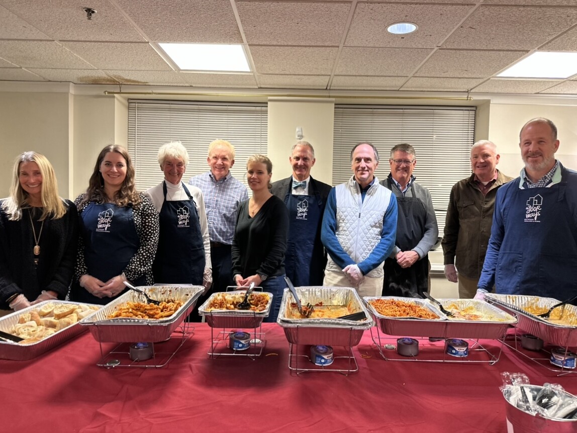Group shot of multiple adults serving food