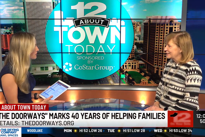 Two adults talk at an anchor desk