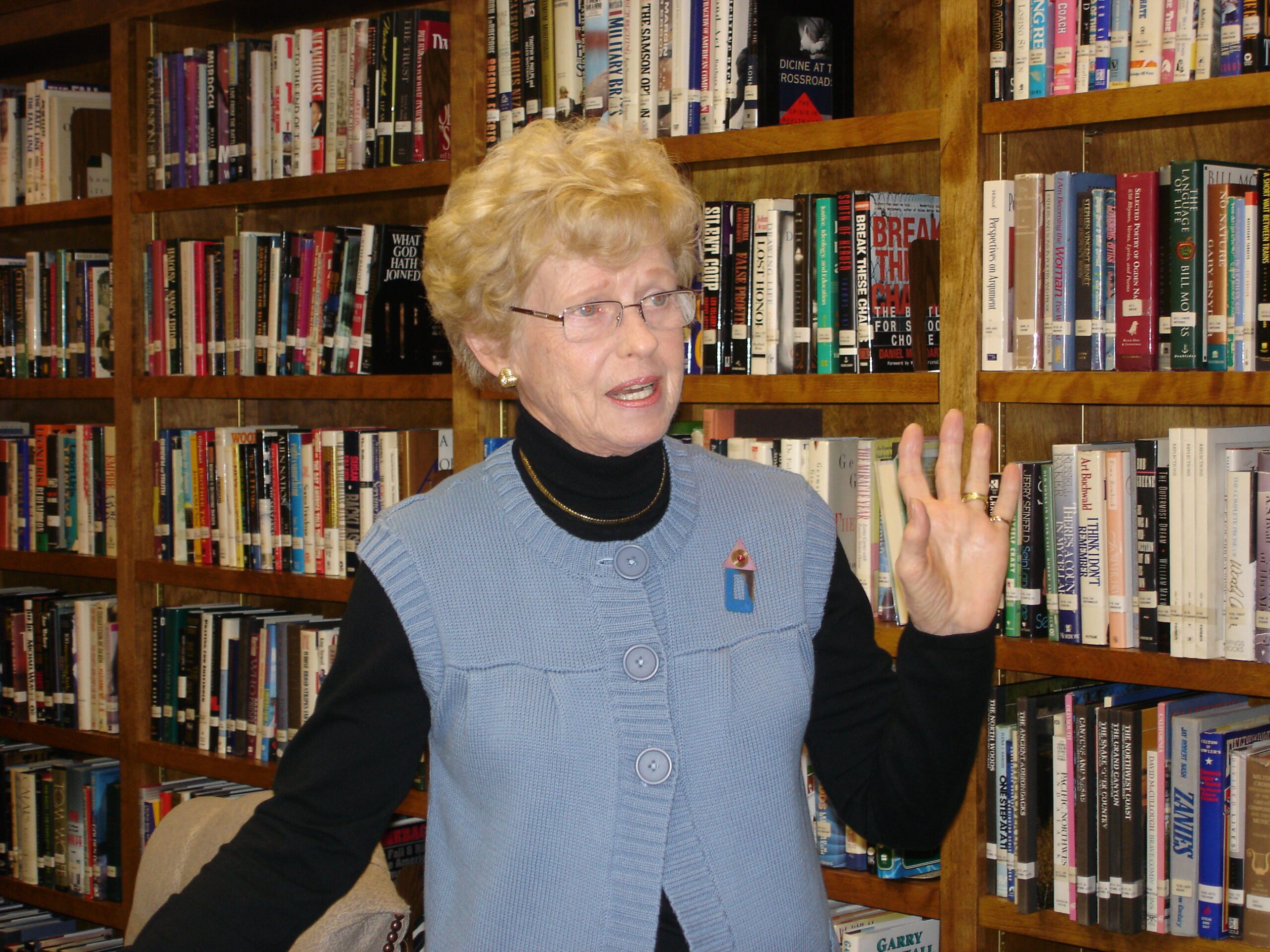 Lunch and Learn with Dolly Jan2009 Photo of Dolly Hintz, an adult, smiling and waving in the library of The Doorways