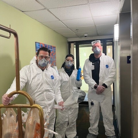 Three Doorways team members wearing sanitation suits in the hallway of The Doorways