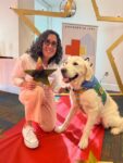a person holds a gold star while posing with their dog