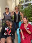 four people hold up peace signs