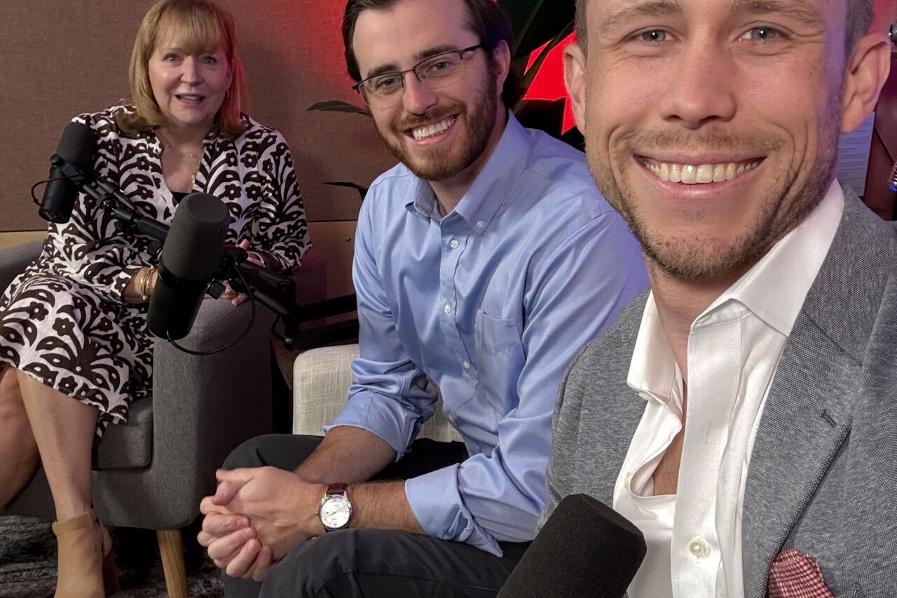 3 smiling adults sit in a podcast studio