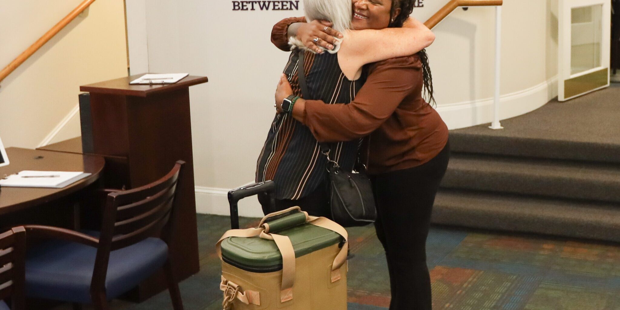 Two people hug in the lobby of The Doorways