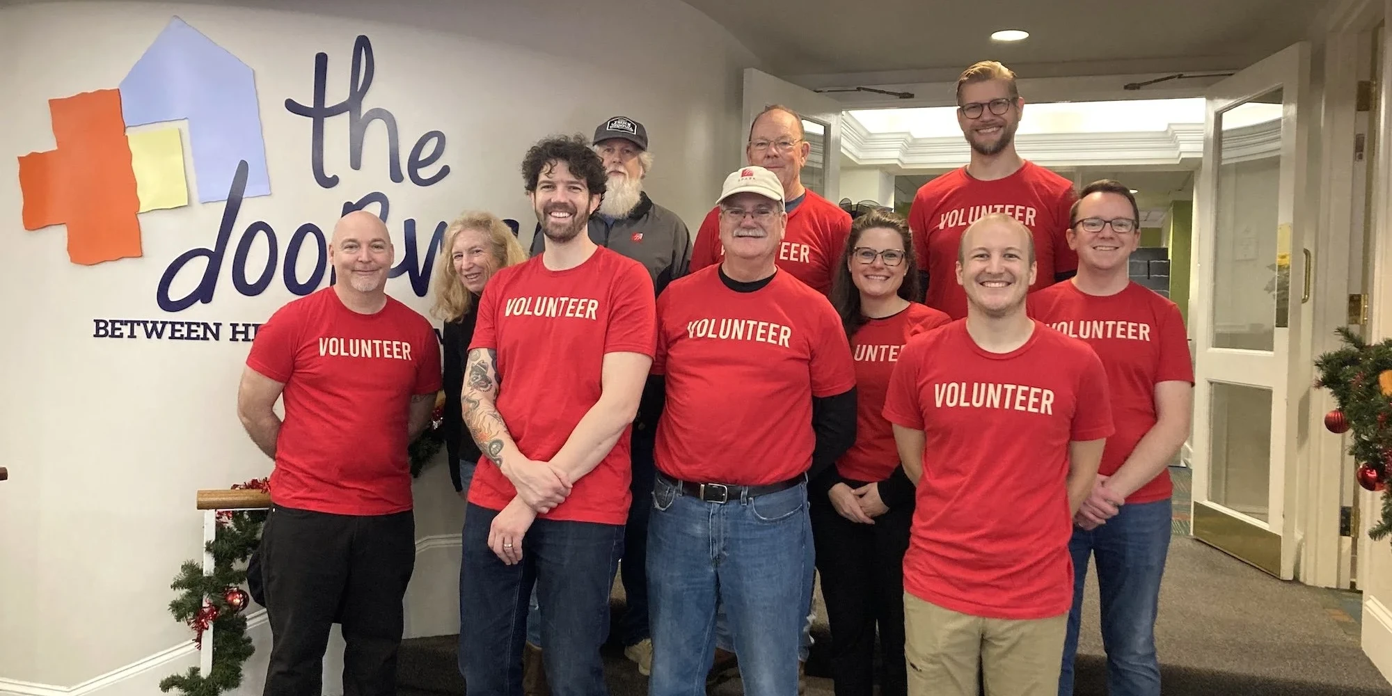 a smiling group of people stand in the lobby of The Doorways