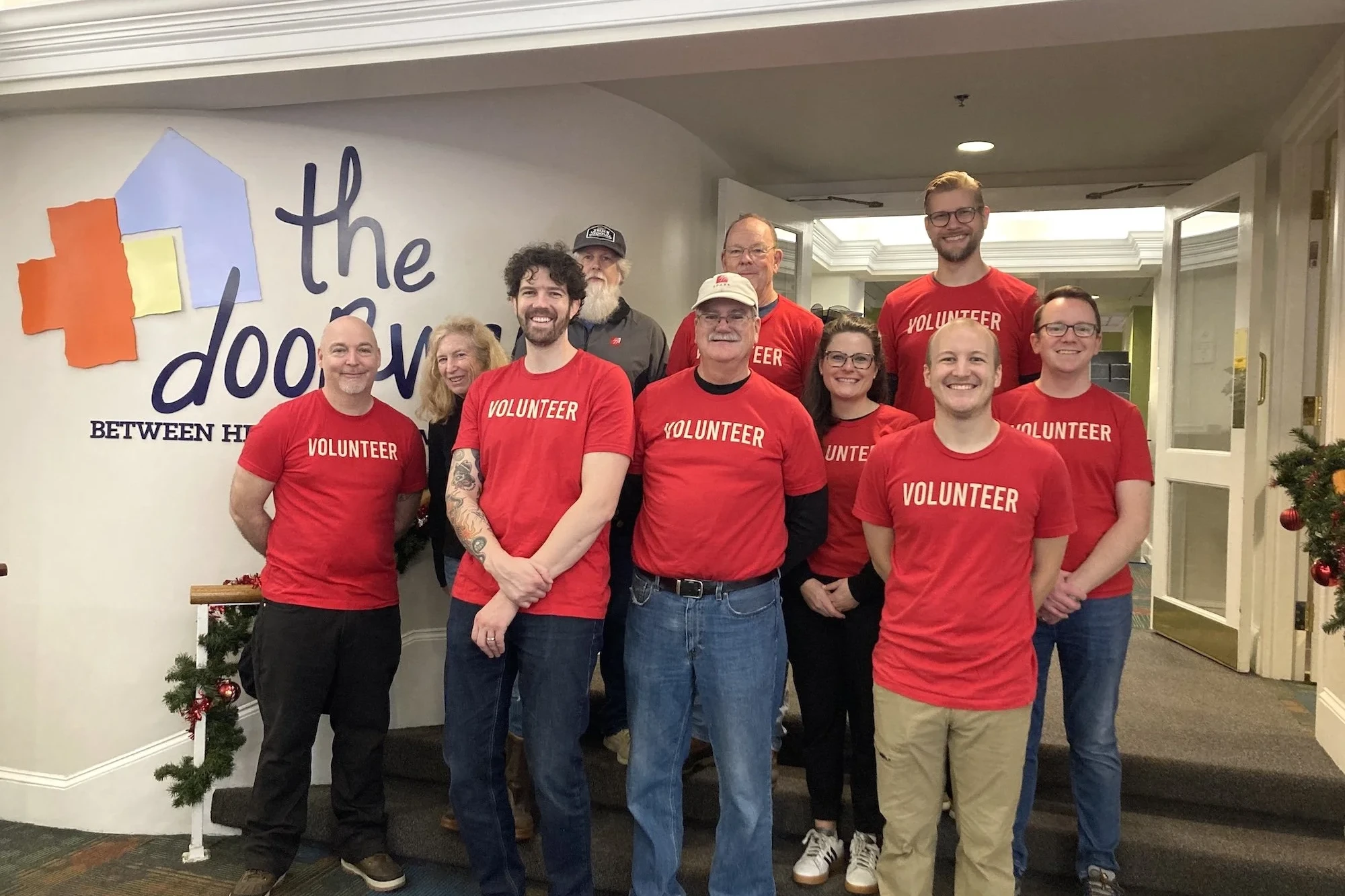 a smiling group of people stand in the lobby of The Doorways