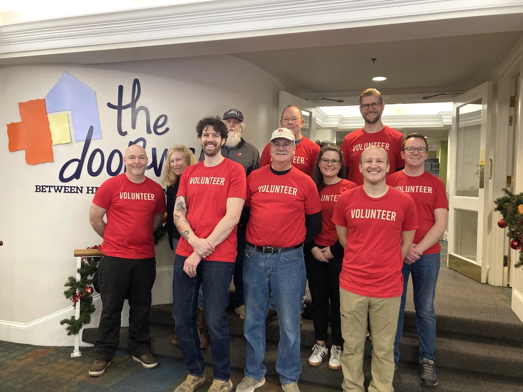 SPARK Product Development a smiling group of people stand in the lobby of The Doorways