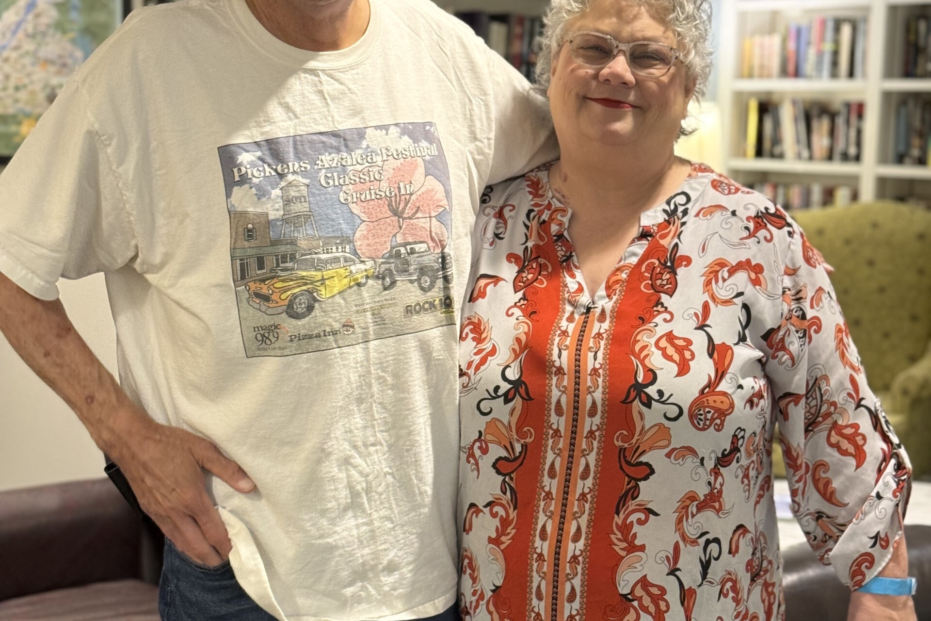 two smiling guests hug each other while in the library of The Doorways