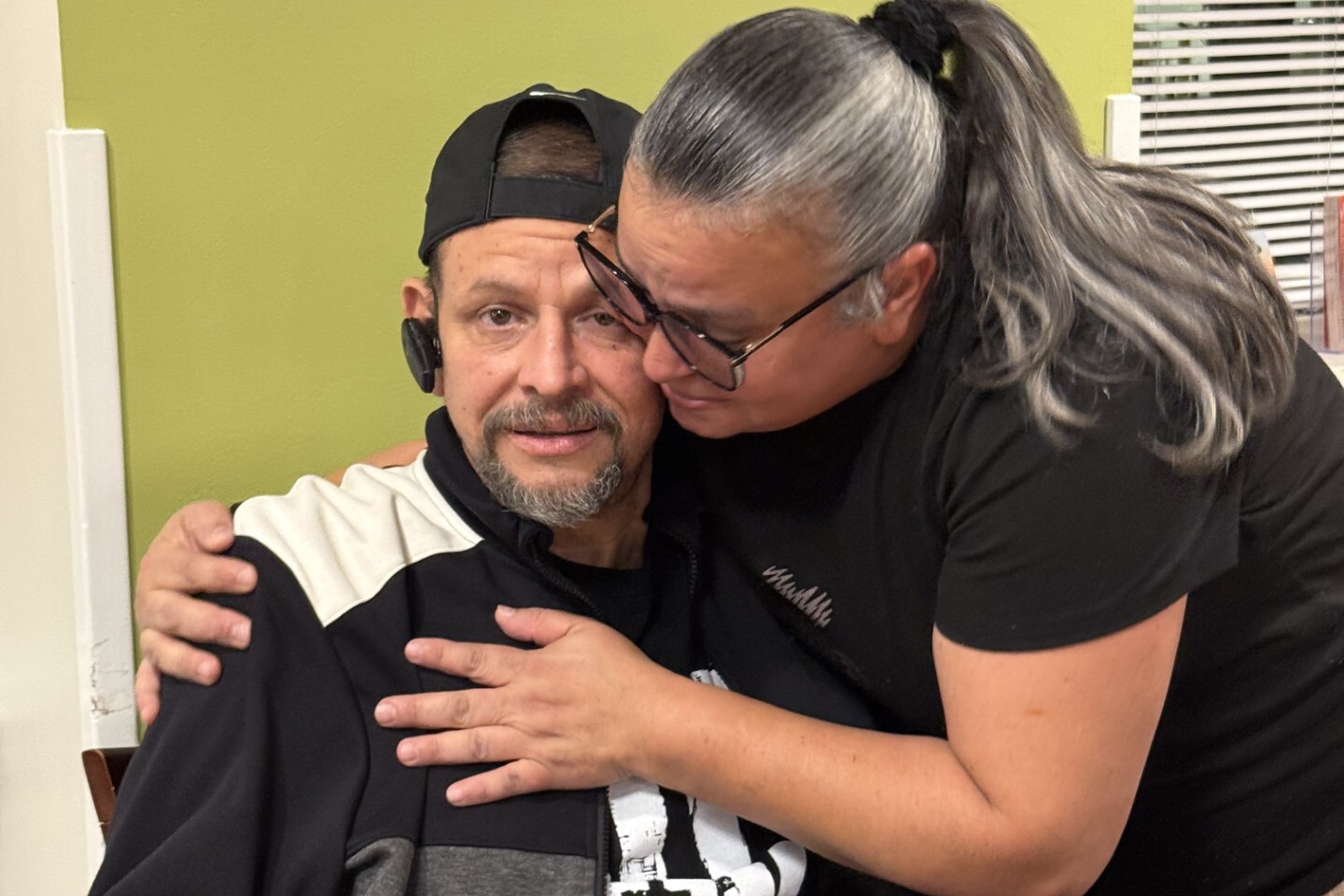 a couple hugs in the dining room of The Doorways