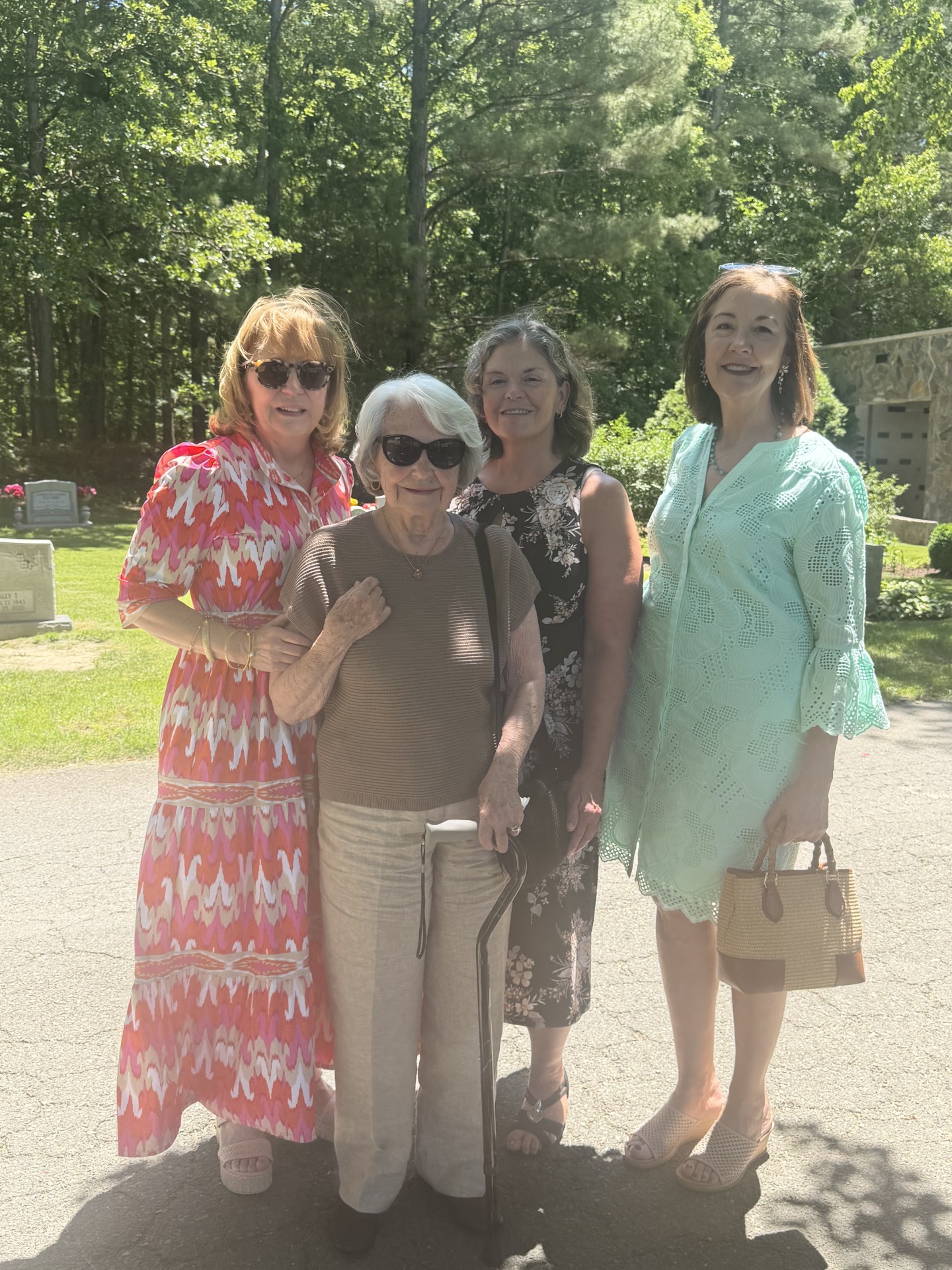 Four smiling people stand in bright clothing outside