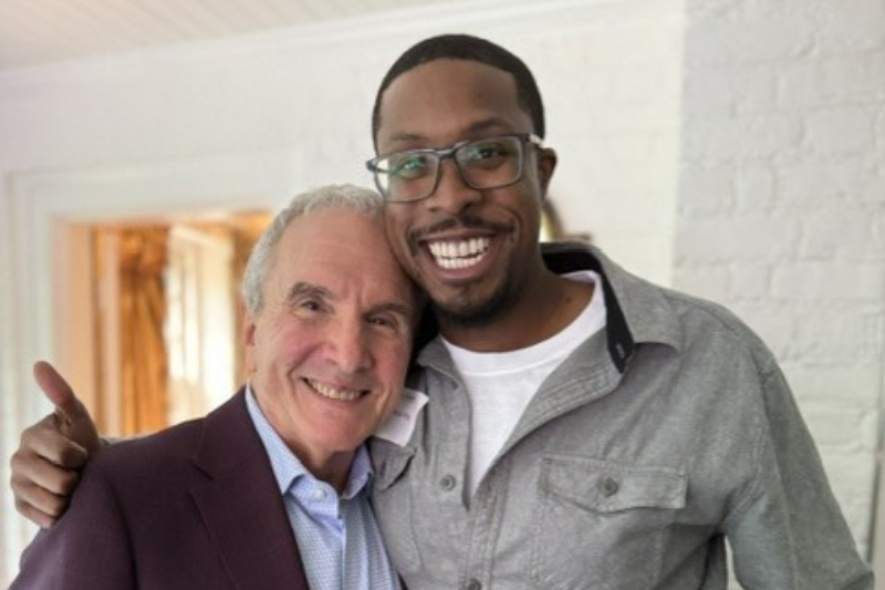 Two smiling adults hug
