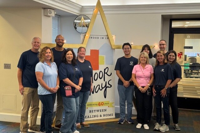 TowneBank team members volunteer at The Doorways and post for a photo in the lobby of The Doorways