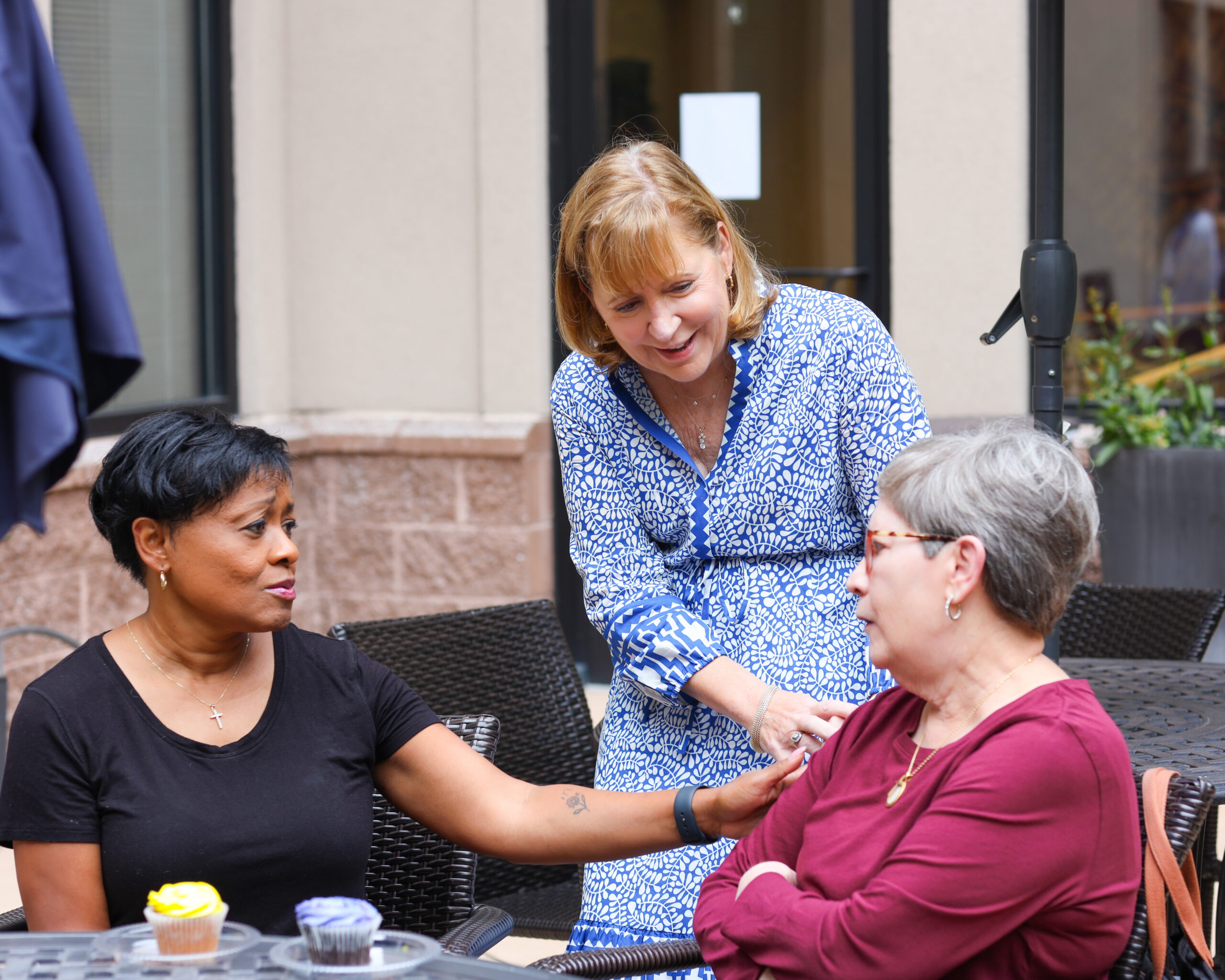 Three adults chat in Dolly's Garden at The Doorways