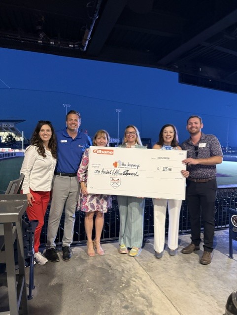 Smiling attendees at the 21st Annual Gilbane Restaurant Walk at CarMax Park with a giant check