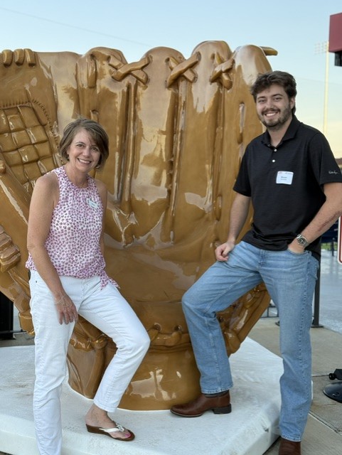 Smiling attendees at the 21st Annual Gilbane Restaurant Walk at CarMax Park pose with a giant baseball glove