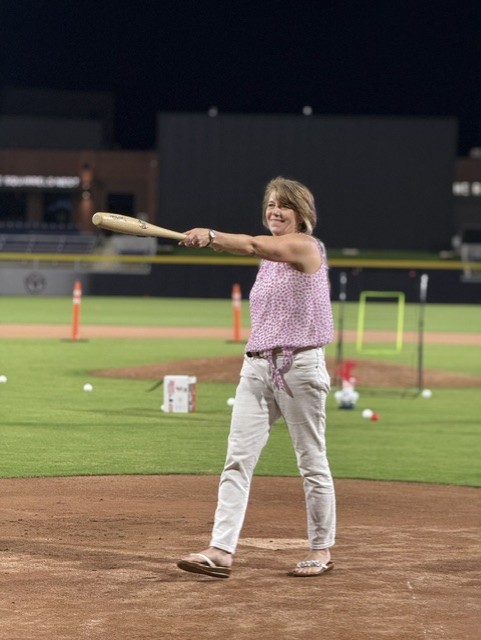 Smiling attendee playing wiffleball at the 21st Annual Gilbane Restaurant Walk at CarMax Park