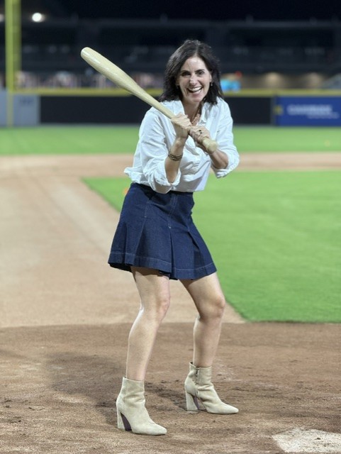 Smiling attendee playing wiffleball at the 21st Annual Gilbane Restaurant Walk at CarMax Park