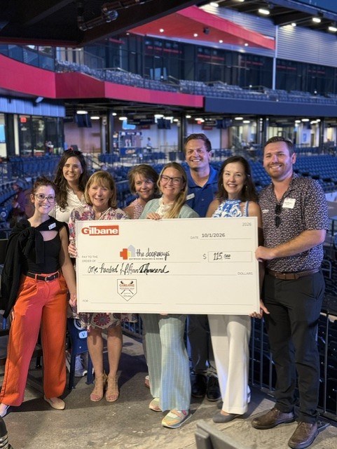 Smiling attendees at the 21st Annual Gilbane Restaurant Walk at CarMax Park with a giant check