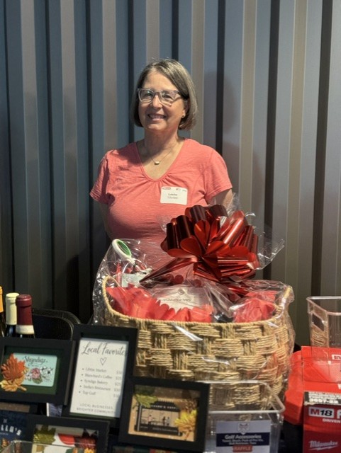 Smiling attendee at the 21st Annual Gilbane Restaurant Walk at CarMax Park poses with raffle prizes