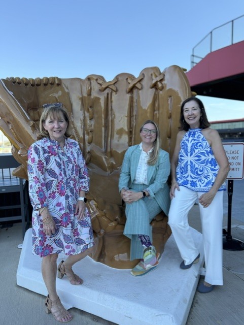 Smiling attendees at the 21st Annual Gilbane Restaurant Walk at CarMax Park pose with a giant baseball glove