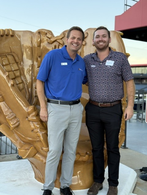Smiling attendees at the 21st Annual Gilbane Restaurant Walk at CarMax Park pose with a giant baseball glove