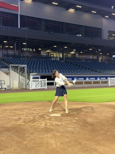 Smiling attendee playing wiffleball at the 21st Annual Gilbane Restaurant Walk at CarMax Park