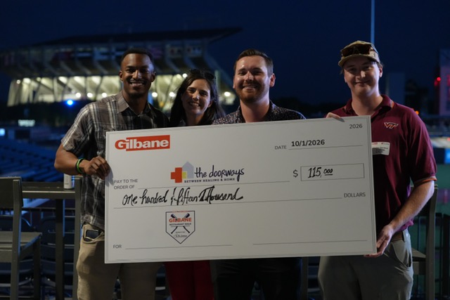 Smiling attendees at the 21st Annual Gilbane Restaurant Walk at CarMax Park with a giant check