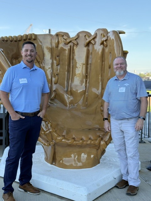 Smiling attendees at the 21st Annual Gilbane Restaurant Walk at CarMax Park pose with a giant baseball glove